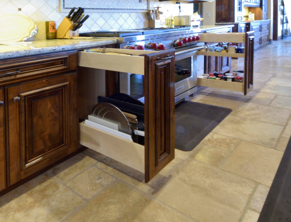 Example of a large transitional u-shaped slate floor and beige floor eat-in kitchen design in Other with a farmhouse sink, raised-panel cabinets, medium tone wood cabinets, granite countertops, beige backsplash, ceramic backsplash, stainless steel appliances, an island and beige countertops