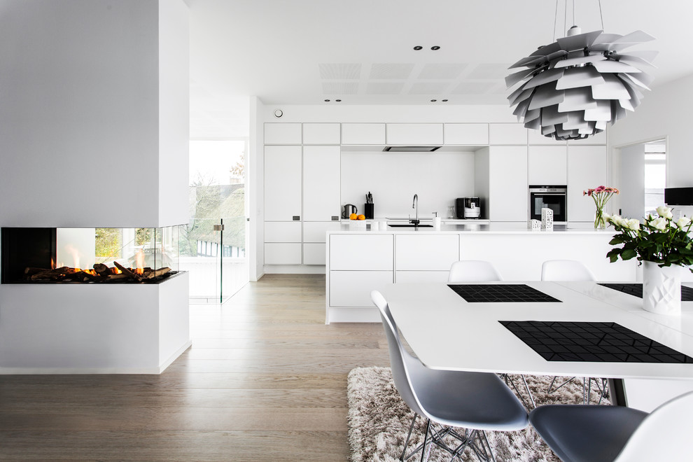 Foto på ett stort minimalistiskt linjärt kök, med vitt stänkskydd, vita vitvaror och brunt golv