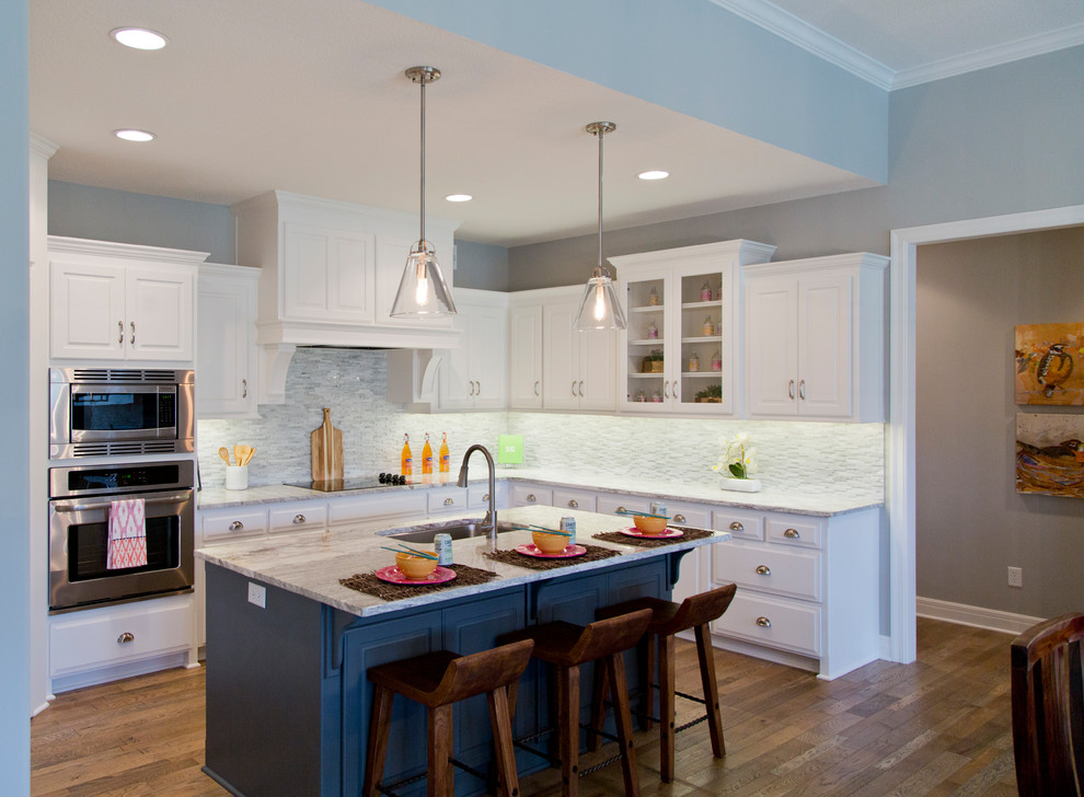 Inspiration for a large eclectic u-shaped medium tone wood floor and brown floor open concept kitchen remodel in Kansas City with an undermount sink, louvered cabinets, white cabinets, granite countertops, multicolored backsplash, matchstick tile backsplash, stainless steel appliances and an island