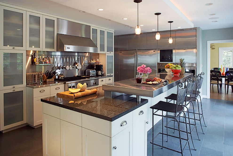 Inspiration for a large contemporary l-shaped enclosed kitchen in Chicago with shaker cabinets, white cabinets, stainless steel worktops, metallic splashback, metal splashback, stainless steel appliances, slate flooring, an island and grey floors.