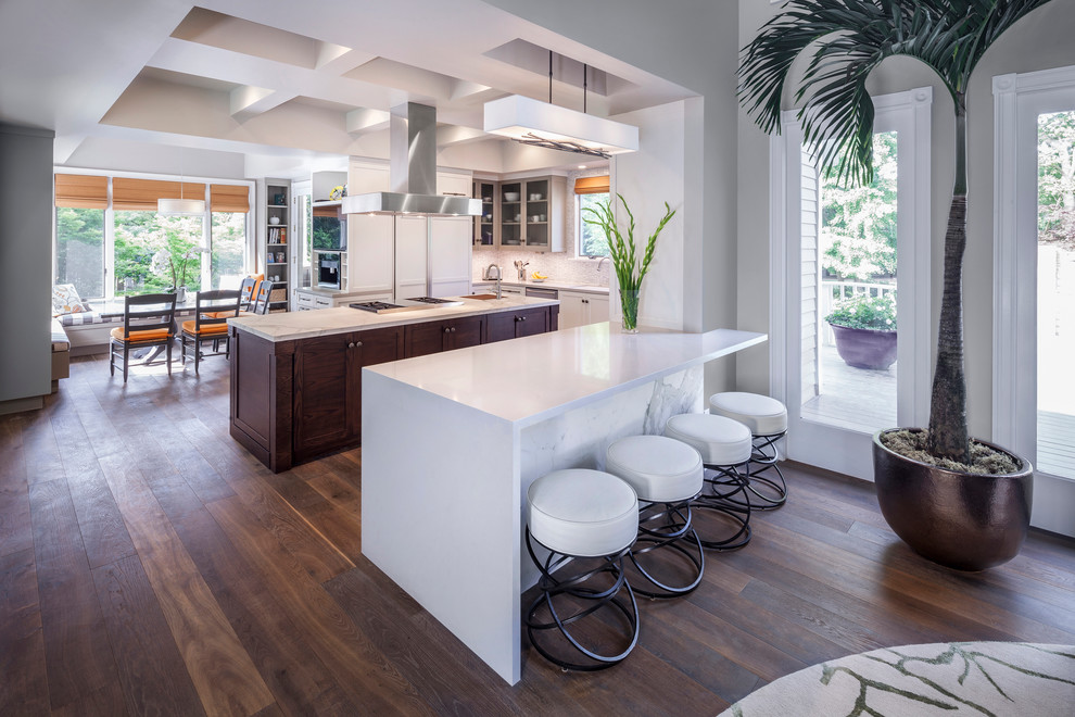 Moderne Wohnküche mit weißen Schränken, Quarzwerkstein-Arbeitsplatte, Küchengeräten aus Edelstahl, braunem Holzboden und Kücheninsel in Sacramento