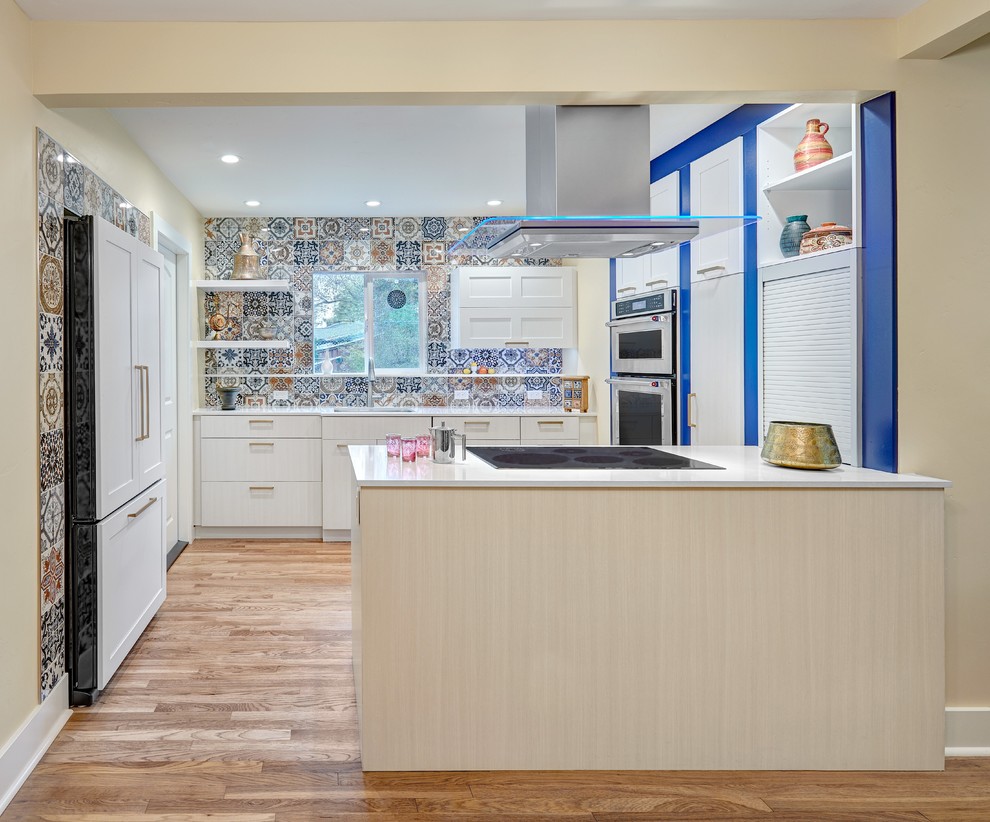 Design ideas for a mediterranean kitchen in Sacramento with a submerged sink, white cabinets, engineered stone countertops, multi-coloured splashback, integrated appliances, medium hardwood flooring, a breakfast bar and shaker cabinets.