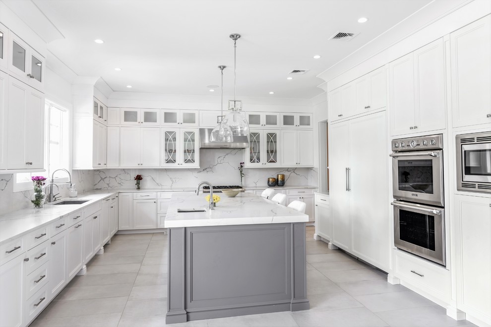 Idéer för att renovera ett avskilt, stort vintage vit vitt u-kök, med en undermonterad diskho, luckor med infälld panel, vita skåp, marmorbänkskiva, vitt stänkskydd, stänkskydd i marmor, rostfria vitvaror, marmorgolv, en köksö och grått golv