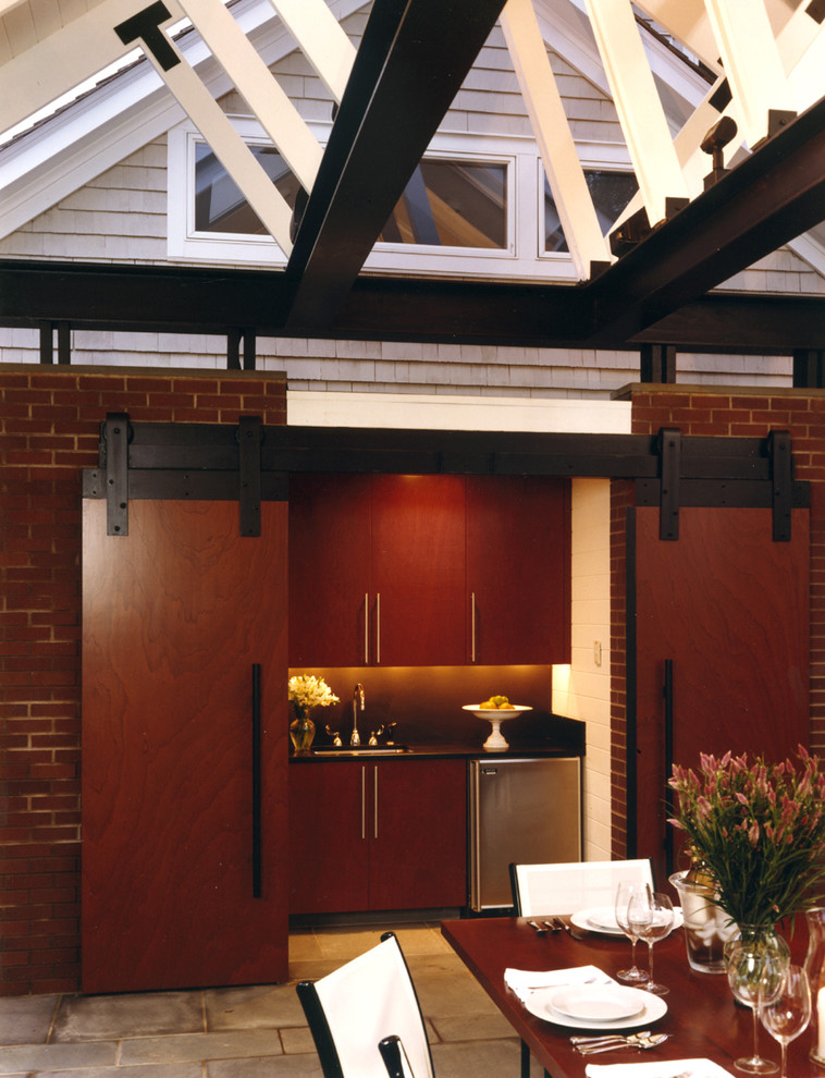 Exempel på ett mellanstort industriellt svart linjärt svart kök och matrum, med en undermonterad diskho, släta luckor, skåp i mörkt trä, granitbänkskiva, svart stänkskydd, stänkskydd i sten, rostfria vitvaror, skiffergolv och blått golv