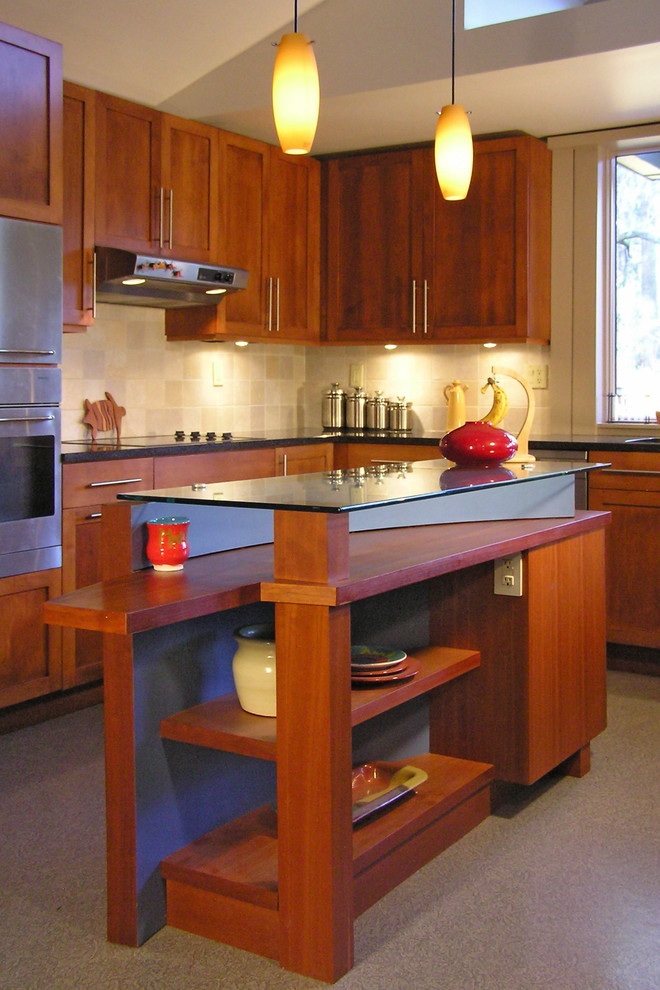 Foto på ett mellanstort funkis kök, med en undermonterad diskho, skåp i shakerstil, skåp i mellenmörkt trä, granitbänkskiva, beige stänkskydd, stänkskydd i porslinskakel, rostfria vitvaror, vinylgolv och en köksö