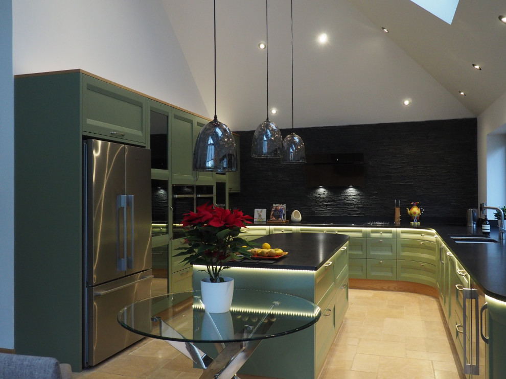 Modern u-shaped kitchen/diner in Kent with green cabinets, granite worktops, integrated appliances, ceramic flooring, an island, beige floors and black worktops.