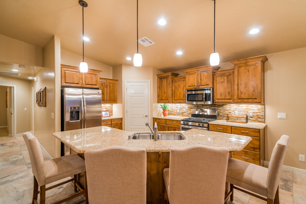 Inspiration for a large timeless l-shaped limestone floor eat-in kitchen remodel in Salt Lake City with raised-panel cabinets, medium tone wood cabinets, an island, granite countertops, a double-bowl sink, multicolored backsplash, matchstick tile backsplash and stainless steel appliances