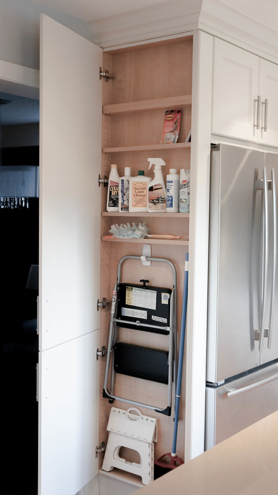 Klassische Küche in U-Form mit Schrankfronten im Shaker-Stil, weißen Schränken, Küchengeräten aus Edelstahl und braunem Holzboden in Toronto