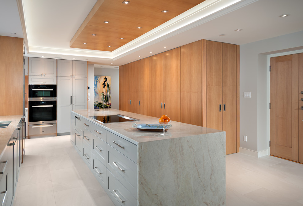 This is an example of a large classic l-shaped kitchen in Vancouver with an island, a double-bowl sink, granite worktops, stainless steel appliances, ceramic flooring and white floors.