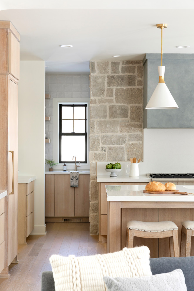 Imagen de cocina comedor escandinava con puertas de armario de madera clara, encimera de cuarcita, electrodomésticos de acero inoxidable, suelo de madera clara y encimeras blancas