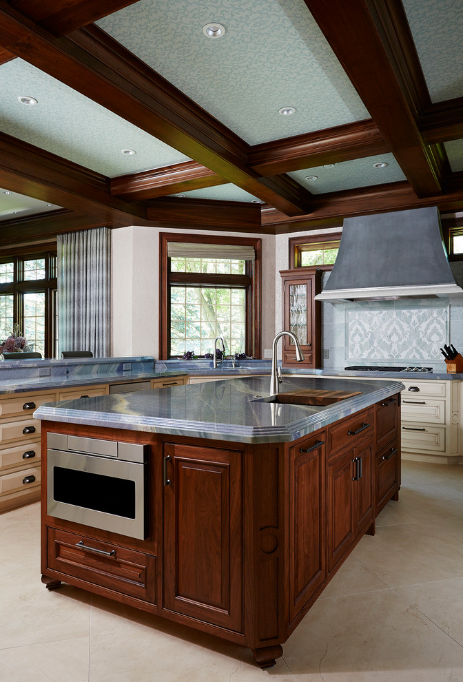 This is an example of a traditional kitchen in Minneapolis with raised-panel cabinets, multi-coloured splashback, stainless steel appliances and an island.