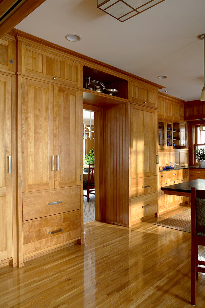Exempel på ett klassiskt kök, med en rustik diskho, luckor med infälld panel, skåp i mellenmörkt trä, grönt stänkskydd, stänkskydd i tunnelbanekakel, integrerade vitvaror, mellanmörkt trägolv och en halv köksö