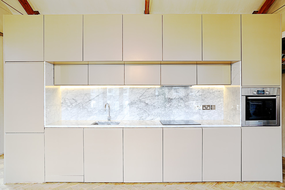 Modern inredning av ett linjärt kök, med en undermonterad diskho och rostfria vitvaror