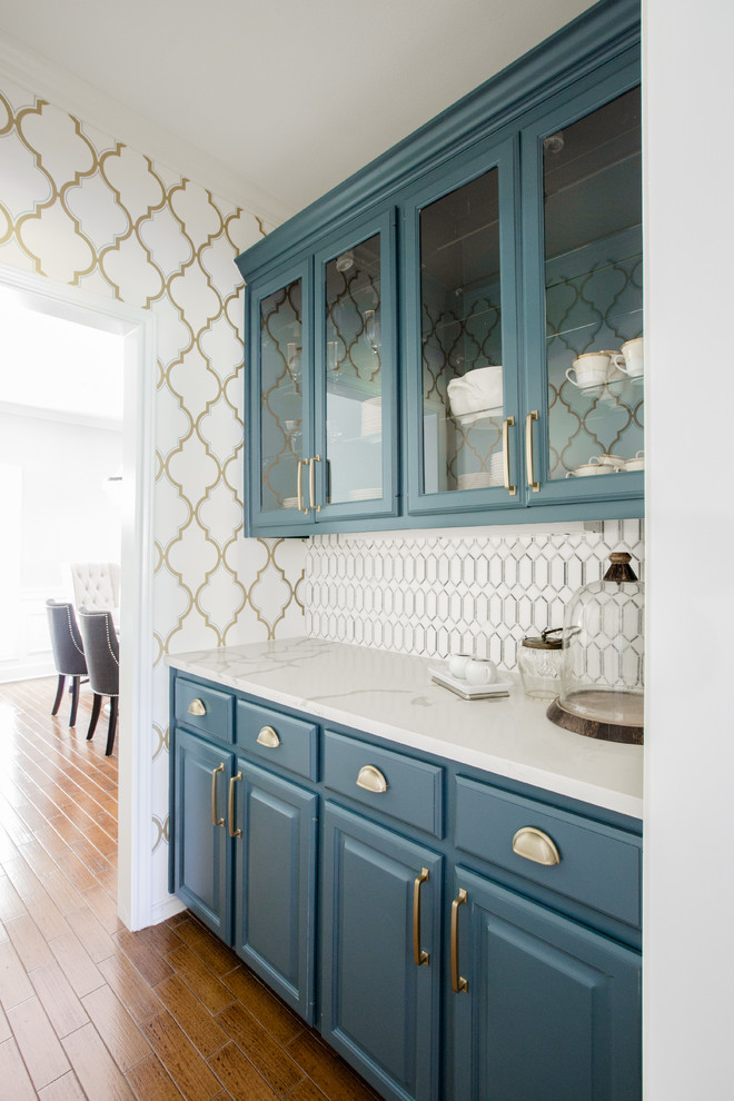 Idee per una cucina classica con ante con bugna sagomata, ante blu, top in quarzite, paraspruzzi bianco, pavimento in legno massello medio, pavimento marrone e top bianco