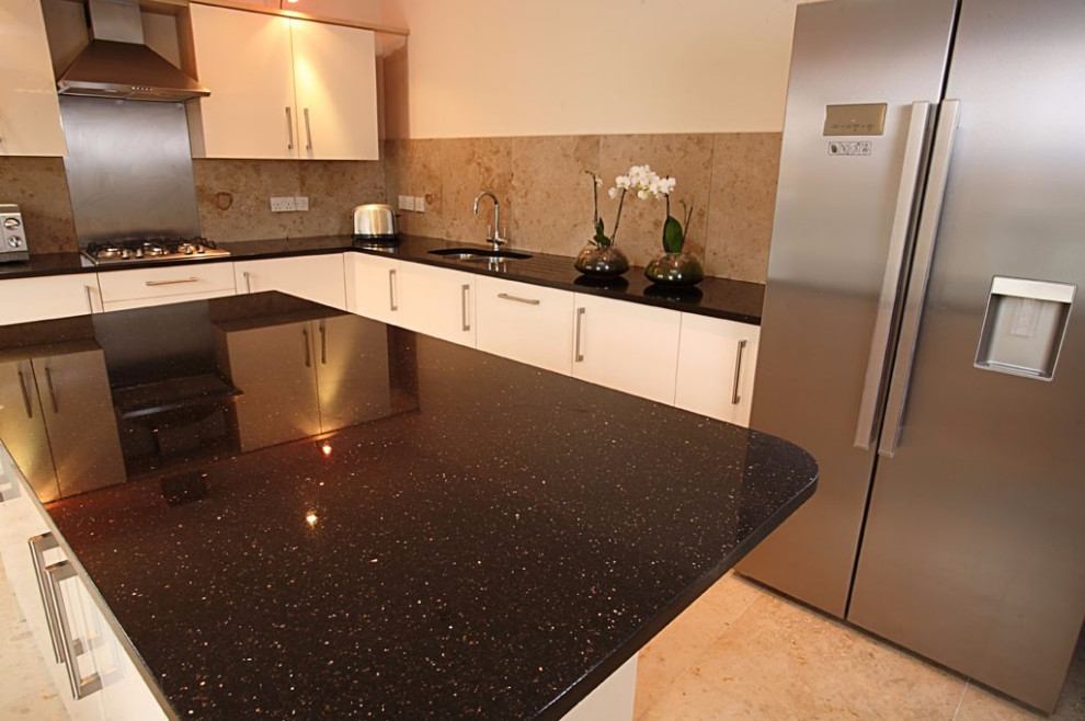 Farmhouse kitchen in London with granite worktops and black worktops.