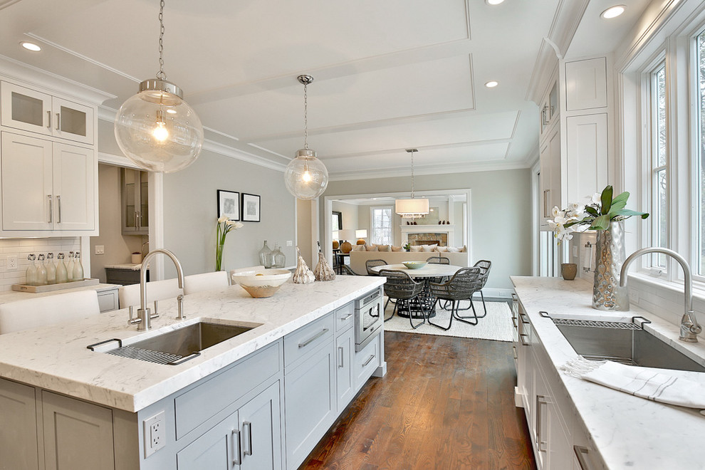 Imagen de cocina gris y blanca tradicional renovada con fregadero bajoencimera, armarios estilo shaker, puertas de armario grises, una isla y suelo de madera oscura