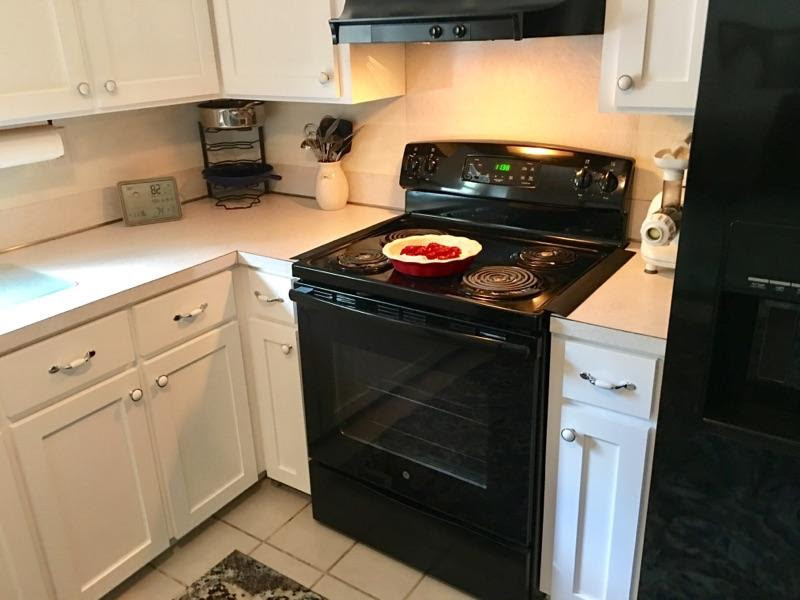 Foto di una cucina chic di medie dimensioni con ante in stile shaker, ante bianche, elettrodomestici neri e nessuna isola