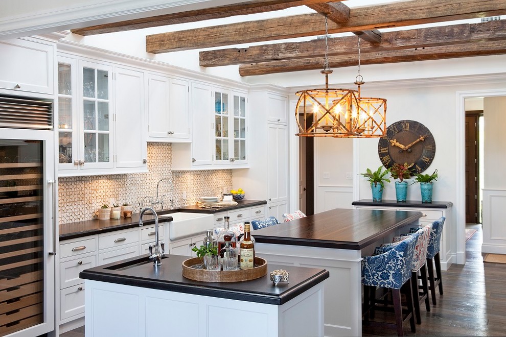 Zweizeilige Klassische Küche mit Landhausspüle, Schrankfronten im Shaker-Stil, weißen Schränken, Arbeitsplatte aus Holz, Küchenrückwand in Grau, dunklem Holzboden und zwei Kücheninseln in Sonstige