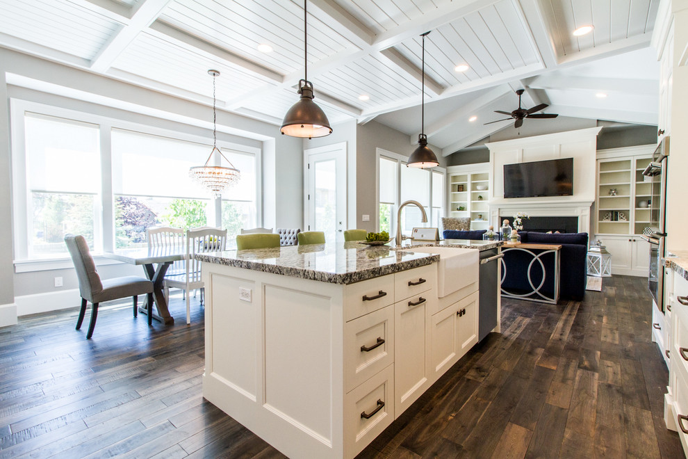 This is an example of a large traditional l-shaped open plan kitchen in Salt Lake City with white cabinets, granite worktops, an island, a submerged sink, shaker cabinets, integrated appliances and dark hardwood flooring.
