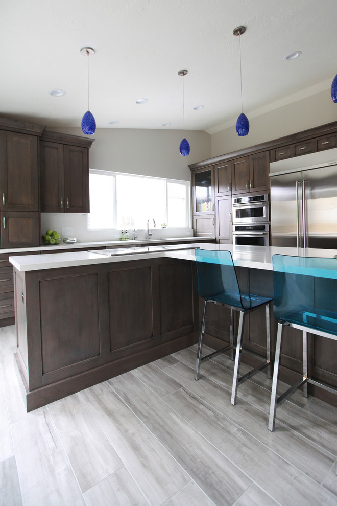 Design ideas for a medium sized classic galley kitchen/diner in Salt Lake City with flat-panel cabinets, granite worktops, white splashback, stainless steel appliances, an island, a submerged sink, dark wood cabinets and ceramic flooring.