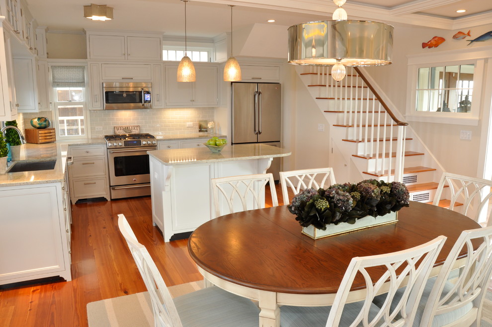 Example of a mid-sized beach style l-shaped medium tone wood floor eat-in kitchen design in Boston with white cabinets, a single-bowl sink, recessed-panel cabinets, white backsplash, stainless steel appliances and an island
