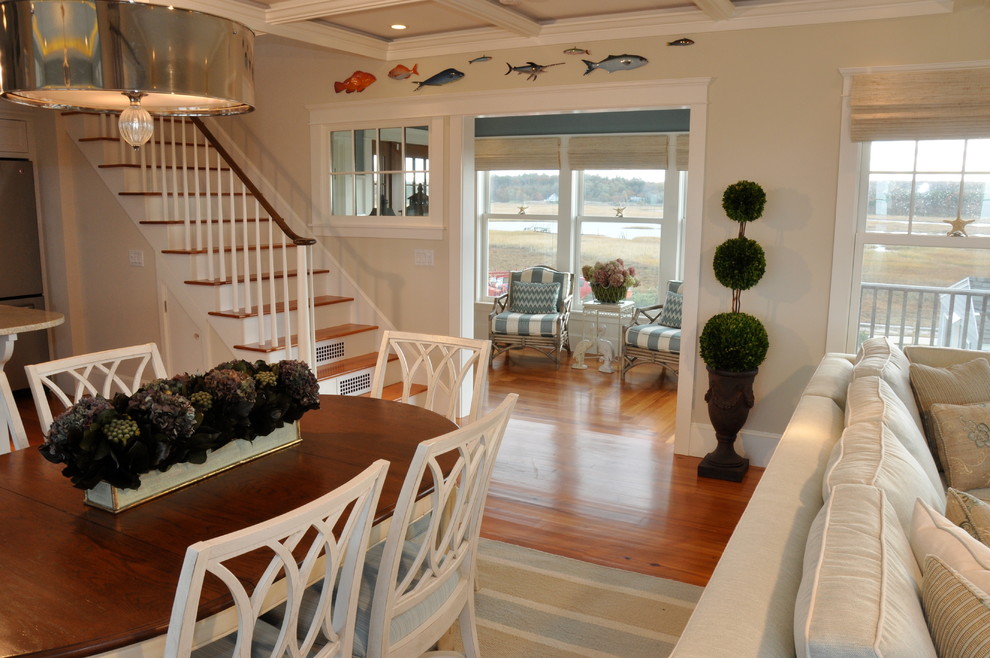 Example of a mid-sized beach style l-shaped medium tone wood floor eat-in kitchen design in Boston with a single-bowl sink, recessed-panel cabinets, white cabinets, white backsplash, stainless steel appliances and an island