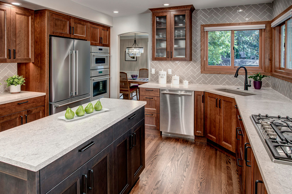 This is an example of a medium sized classic galley kitchen/diner in Seattle with a submerged sink, shaker cabinets, red cabinets, engineered stone countertops, beige splashback, ceramic splashback, stainless steel appliances, medium hardwood flooring, an island, red floors and beige worktops.