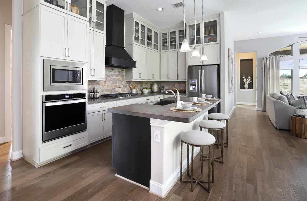 Exempel på ett mellanstort klassiskt grå grått kök, med en undermonterad diskho, bänkskiva i koppar, flerfärgad stänkskydd, stänkskydd i tegel, rostfria vitvaror, en köksö, brunt golv, skåp i shakerstil, vita skåp och mörkt trägolv