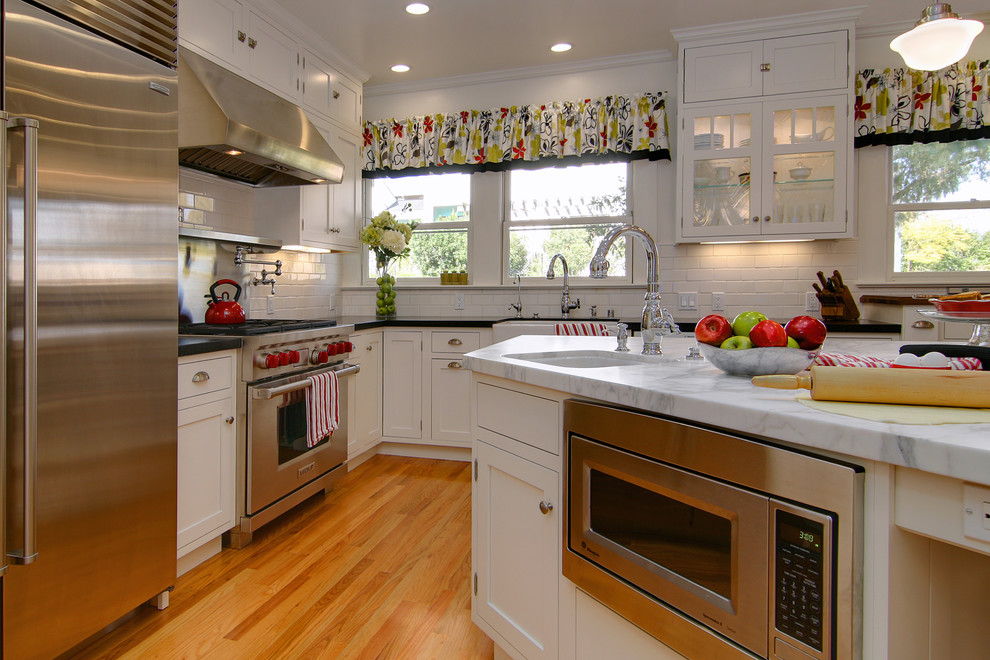 Imagen de cocina clásica con electrodomésticos de acero inoxidable y fregadero sobremueble