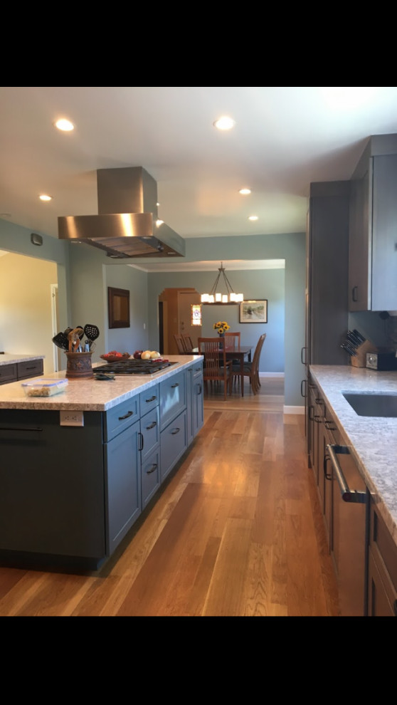 Exempel på ett stort klassiskt grå grått kök, med en undermonterad diskho, släta luckor, skåp i mellenmörkt trä, bänkskiva i kvarts, flerfärgad stänkskydd, stänkskydd i porslinskakel, rostfria vitvaror, ljust trägolv, en köksö och brunt golv