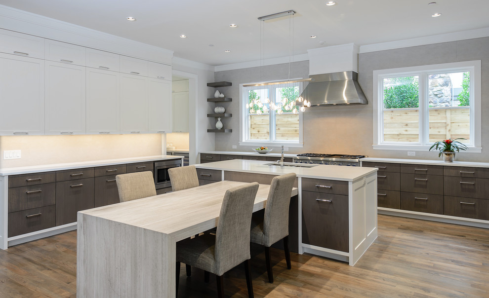Inspiration for a large contemporary u-shaped kitchen/diner in Dallas with a double-bowl sink, flat-panel cabinets, dark wood cabinets, quartz worktops, grey splashback, stone tiled splashback, stainless steel appliances, medium hardwood flooring, multiple islands and brown floors.