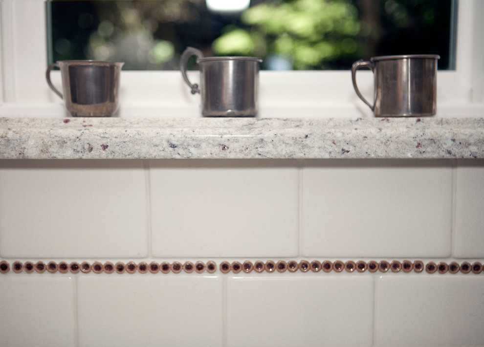 Klassisk inredning av ett mellanstort kök, med en rustik diskho, skåp i shakerstil, vita skåp, vitt stänkskydd, stänkskydd i keramik, rostfria vitvaror, mellanmörkt trägolv, en halv köksö och granitbänkskiva