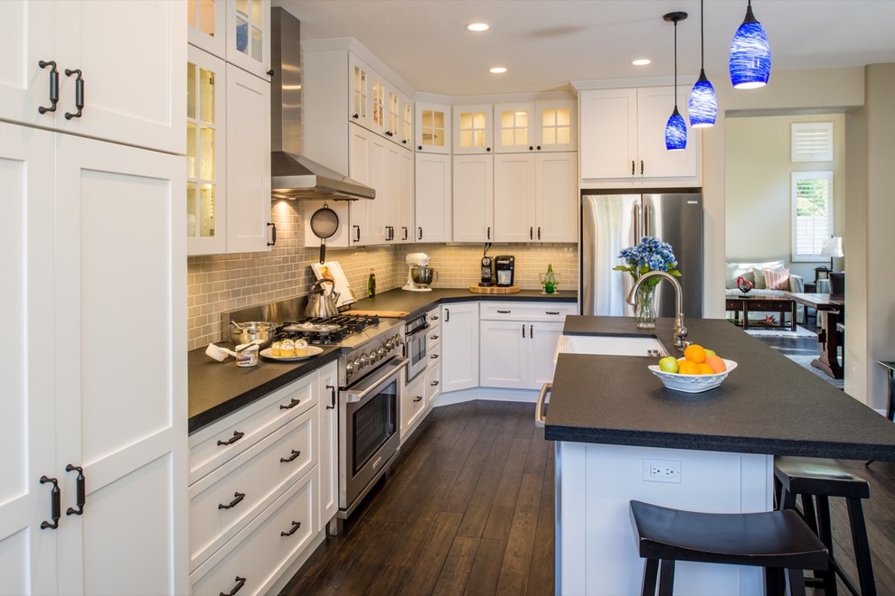 Classic l-shaped kitchen/diner in San Diego with a built-in sink, recessed-panel cabinets, white cabinets, composite countertops, beige splashback, metro tiled splashback and stainless steel appliances.