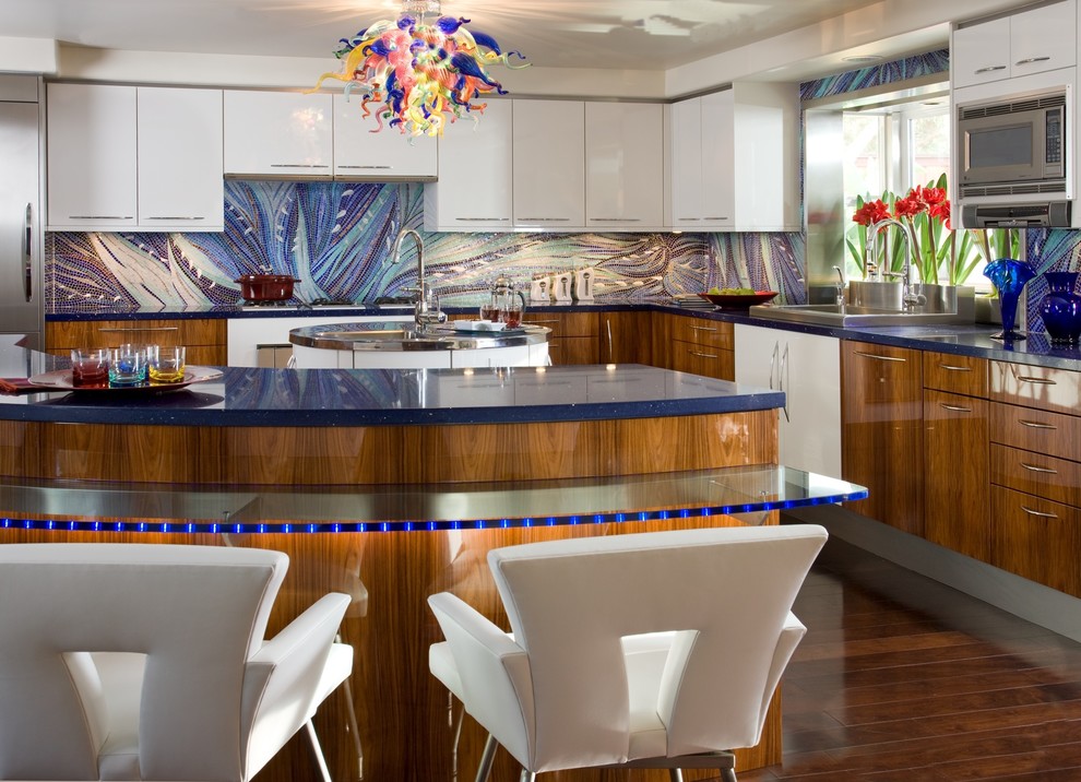 Moderne Küche in L-Form mit Rückwand aus Mosaikfliesen, Glas-Arbeitsplatte, Küchenrückwand in Blau, Einbauwaschbecken, flächenbündigen Schrankfronten, weißen Schränken, Küchengeräten aus Edelstahl und blauer Arbeitsplatte in San Diego