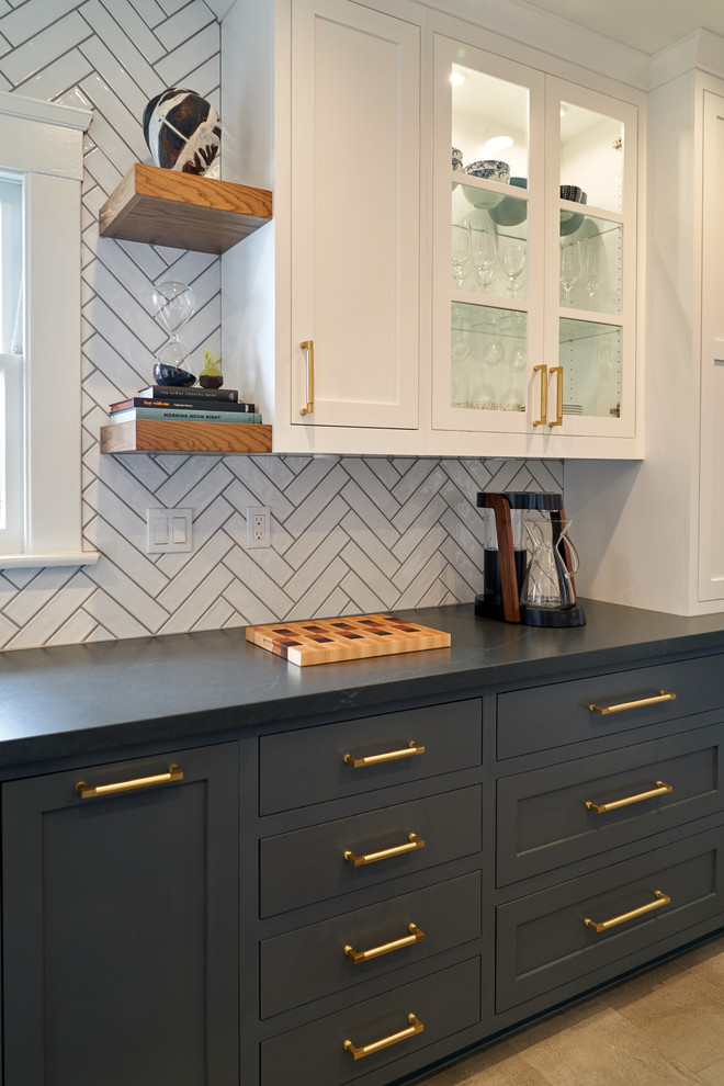 Mid-sized transitional galley porcelain tile and gray floor kitchen photo in San Diego with a farmhouse sink, shaker cabinets, blue cabinets, quartz countertops, white backsplash, ceramic backsplash, black appliances and gray countertops