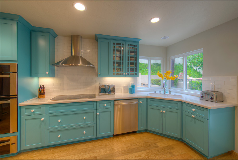 Example of a mid-sized trendy l-shaped light wood floor eat-in kitchen design in San Diego with an undermount sink, shaker cabinets, turquoise cabinets, granite countertops, white backsplash, subway tile backsplash, stainless steel appliances and an island