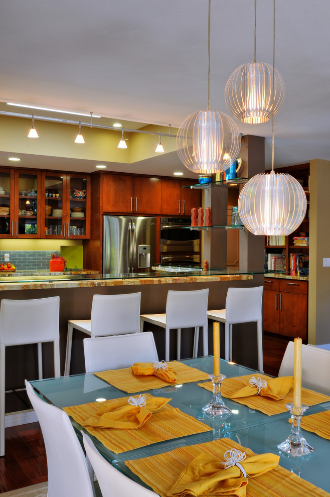 Bild på ett stort funkis flerfärgad flerfärgat kök, med en dubbel diskho, släta luckor, bruna skåp, granitbänkskiva, blått stänkskydd, stänkskydd i tunnelbanekakel, rostfria vitvaror, mörkt trägolv, en köksö och brunt golv