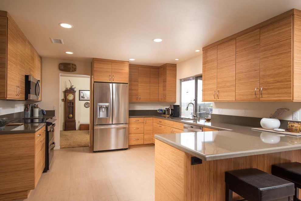 Photo of a medium sized modern l-shaped kitchen/diner in San Diego with a submerged sink, flat-panel cabinets, engineered stone countertops, grey splashback, stainless steel appliances, porcelain flooring and a breakfast bar.