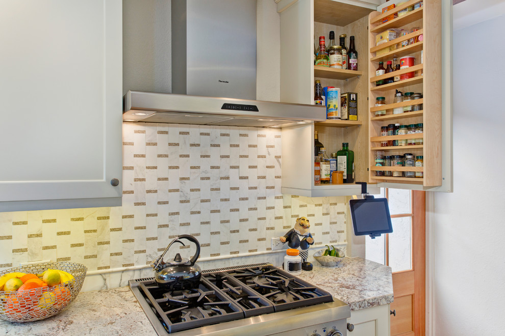 Foto på ett mellanstort vintage kök, med en undermonterad diskho, skåp i shakerstil, vita skåp, granitbänkskiva, vitt stänkskydd, stänkskydd i mosaik, rostfria vitvaror och mellanmörkt trägolv