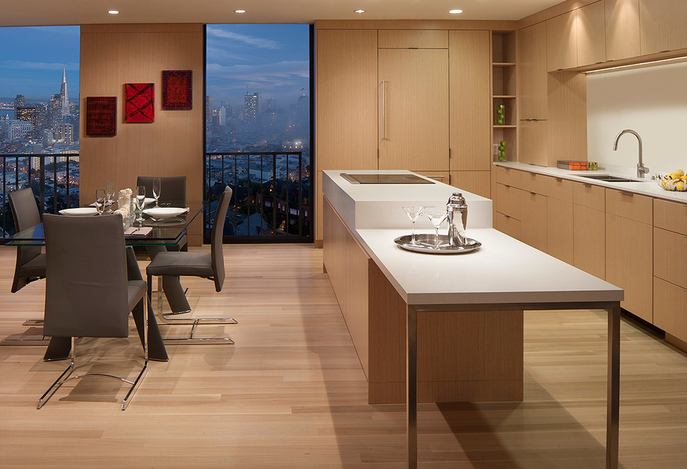 Photo of a contemporary u-shaped kitchen/diner in San Francisco with a double-bowl sink, flat-panel cabinets, light wood cabinets, integrated appliances and light hardwood flooring.