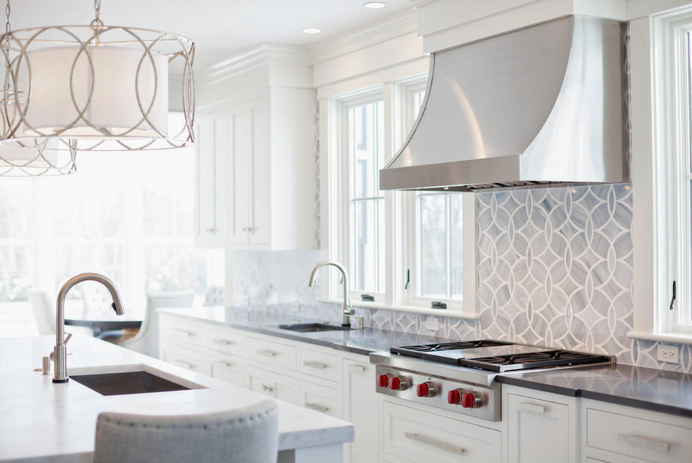 Foto di una grande cucina design con ante con riquadro incassato, ante bianche e top in marmo