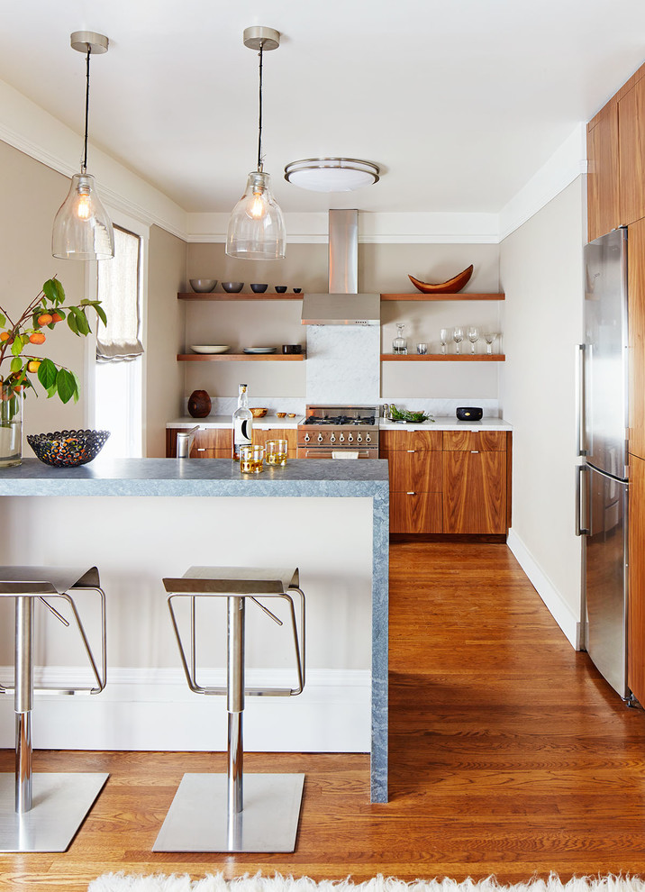 Zweizeilige Moderne Küche mit flächenbündigen Schrankfronten, hellbraunen Holzschränken, Küchenrückwand in Weiß, Rückwand aus Stein, Küchengeräten aus Edelstahl, braunem Holzboden, Halbinsel und blauer Arbeitsplatte in San Francisco