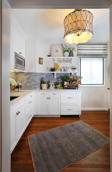Example of a small classic l-shaped medium tone wood floor kitchen design in San Francisco with a drop-in sink, shaker cabinets, white cabinets, marble countertops, gray backsplash, stone tile backsplash, stainless steel appliances and no island