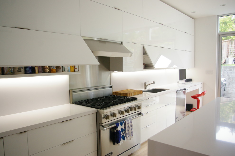 На фото: глянцевая кухня в стиле модернизм с врезной мойкой, плоскими фасадами и белыми фасадами с