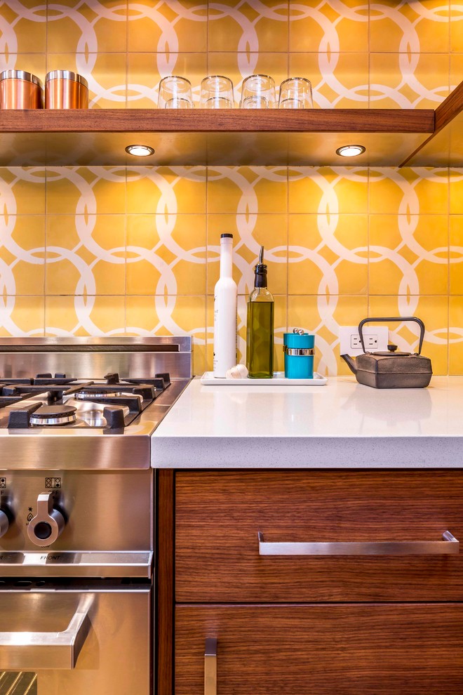 Ejemplo de cocina moderna con armarios con paneles lisos, encimera de cuarzo compacto, salpicadero amarillo, salpicadero de azulejos de cemento y electrodomésticos de acero inoxidable
