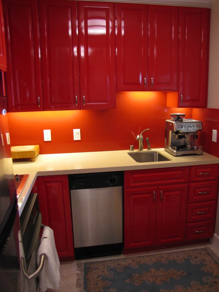 サンフランシスコにある低価格の小さなコンテンポラリースタイルのおしゃれなキッチン (アンダーカウンターシンク、レイズドパネル扉のキャビネット、赤いキャビネット、人工大理石カウンター、赤いキッチンパネル、セラミックタイルのキッチンパネル、シルバーの調理設備、セラミックタイルの床) の写真