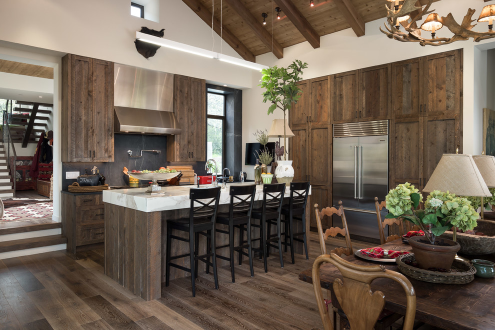 This is an example of a medium sized rustic l-shaped open plan kitchen in San Francisco with a submerged sink, marble splashback, stainless steel appliances, an island, brown floors, black splashback, white worktops, shaker cabinets, dark wood cabinets and dark hardwood flooring.