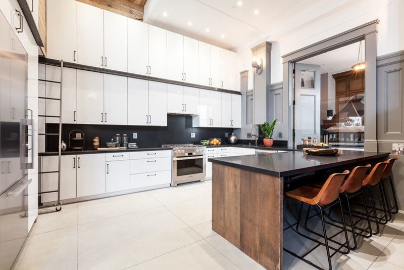 Inspiration for a large modern l-shaped porcelain tile and beige floor eat-in kitchen remodel in San Francisco with white cabinets, stainless steel appliances, black backsplash, no island, an undermount sink, flat-panel cabinets, solid surface countertops and stone slab backsplash