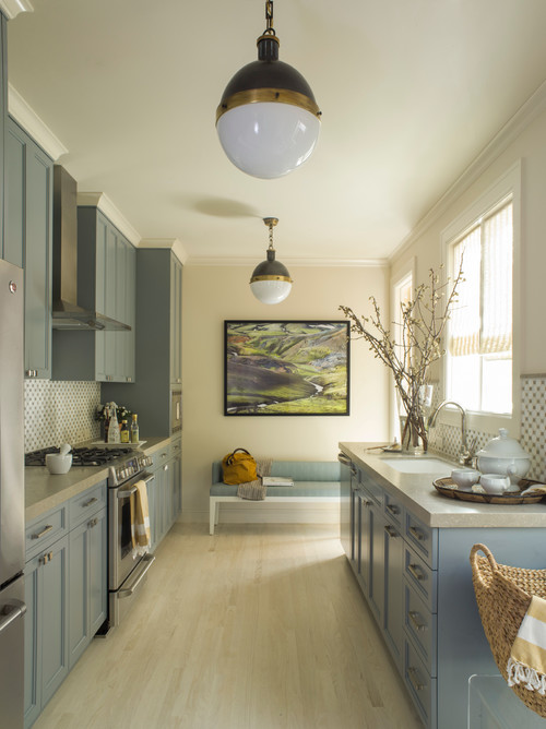 Galley kitchen with soft blue cabinets, light countertops, and cozy family atmosphere