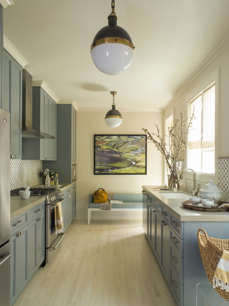 Photo of a classic grey and cream galley kitchen in San Francisco with a submerged sink, shaker cabinets, multi-coloured splashback, stainless steel appliances, light hardwood flooring, no island and grey cabinets.